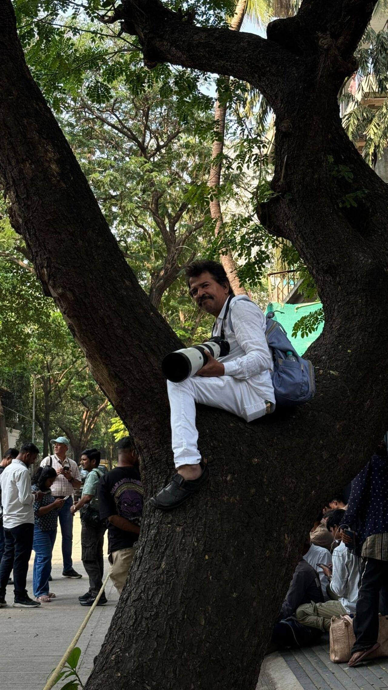 A photographer was seen sitting atop a tree branch outside Dharmendra's Juhu residence (Pic/ Atul Kamble)